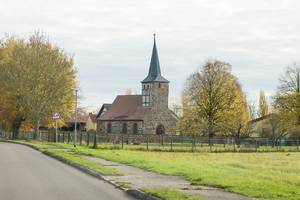 links die Landstraße, im Hintergrund die Kirche von Windberge