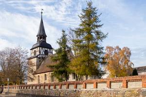 Kirche in Uchtdorf mit Friedhofsmauer im Vordergrund