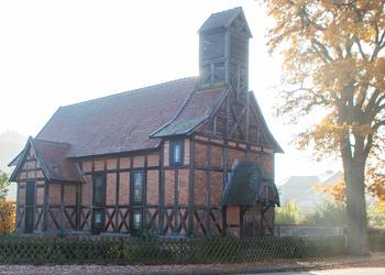 Fachwerkkirche Birkholz mit großem Baum rechts
