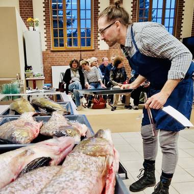 Fisch liegt für die Zubereitung auf Backblechen bereit