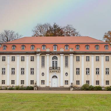 Frontalaufnahme des neuen Schloss in Tangerhütte mit Regenbogen im Hintergrund