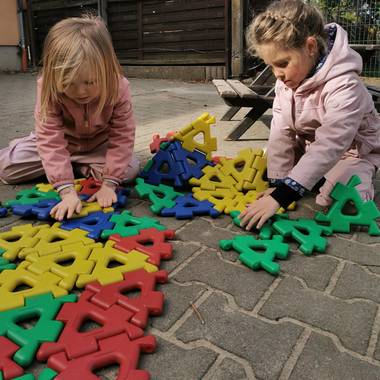 zwei Kinder sitzen auf dem Boden und testen das neue Konstruktionsspielzeug