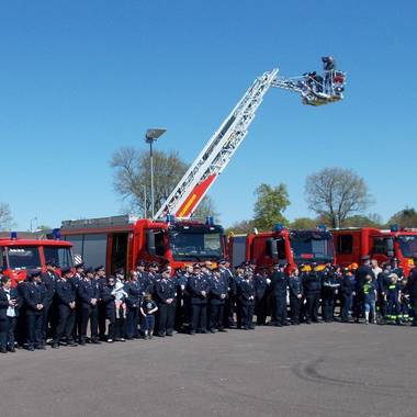 ein Gruppenbild der Feuerwehrleute vor den Feuerwehrfahrzeugen