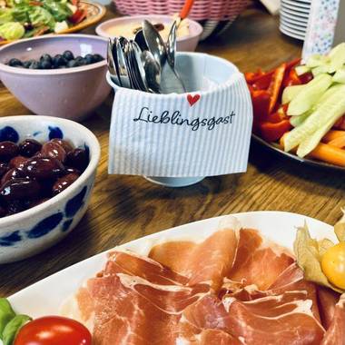 eine Auswahl gesunder Lebensmittel und ein Becher mit Besteck in der Mitte