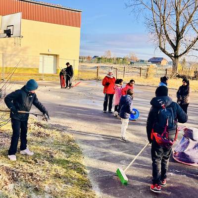 Jugendliche fegen den Bereich hinter dem Jugendclub Tangerhütte