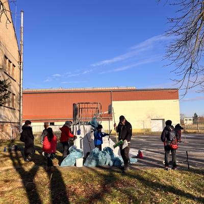 Jugendliche und Erwachsene beim Aufräumen. Einige Müllbeutel sind schon voll.