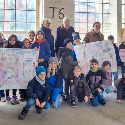 ein Gruppenbild der Hortkinder mit Erziehern und Herrn Dr. Dreihaupt; die Kinder halten Plakate zum Thema Industriekultur