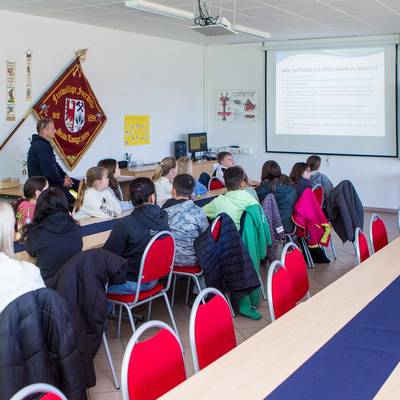 Die Kinder schauen sich im Versammlungsraum der Feuerwehr Tangerhütte eine Präsentation zum Thema "Wie verhalte ich mich, wenn es brennt?" an.