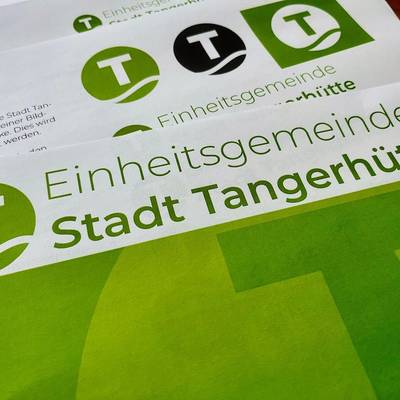 Das neue Logo der Einheitsgemeinde zusammen mit dem Schriftzug auf diversen Dokumenten.