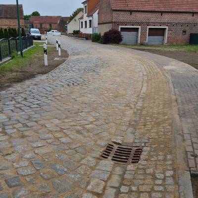 Kopfsteinpflasterstraße die erneuert wurde, in die entstehenden Steinzwischenräume wurde feiner Sand eingefegt